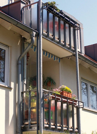 Balkon mit Glasgeländer und Blumenkastenhalter